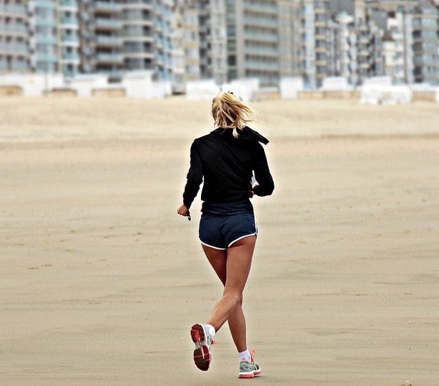 mujer corriendo por la playa